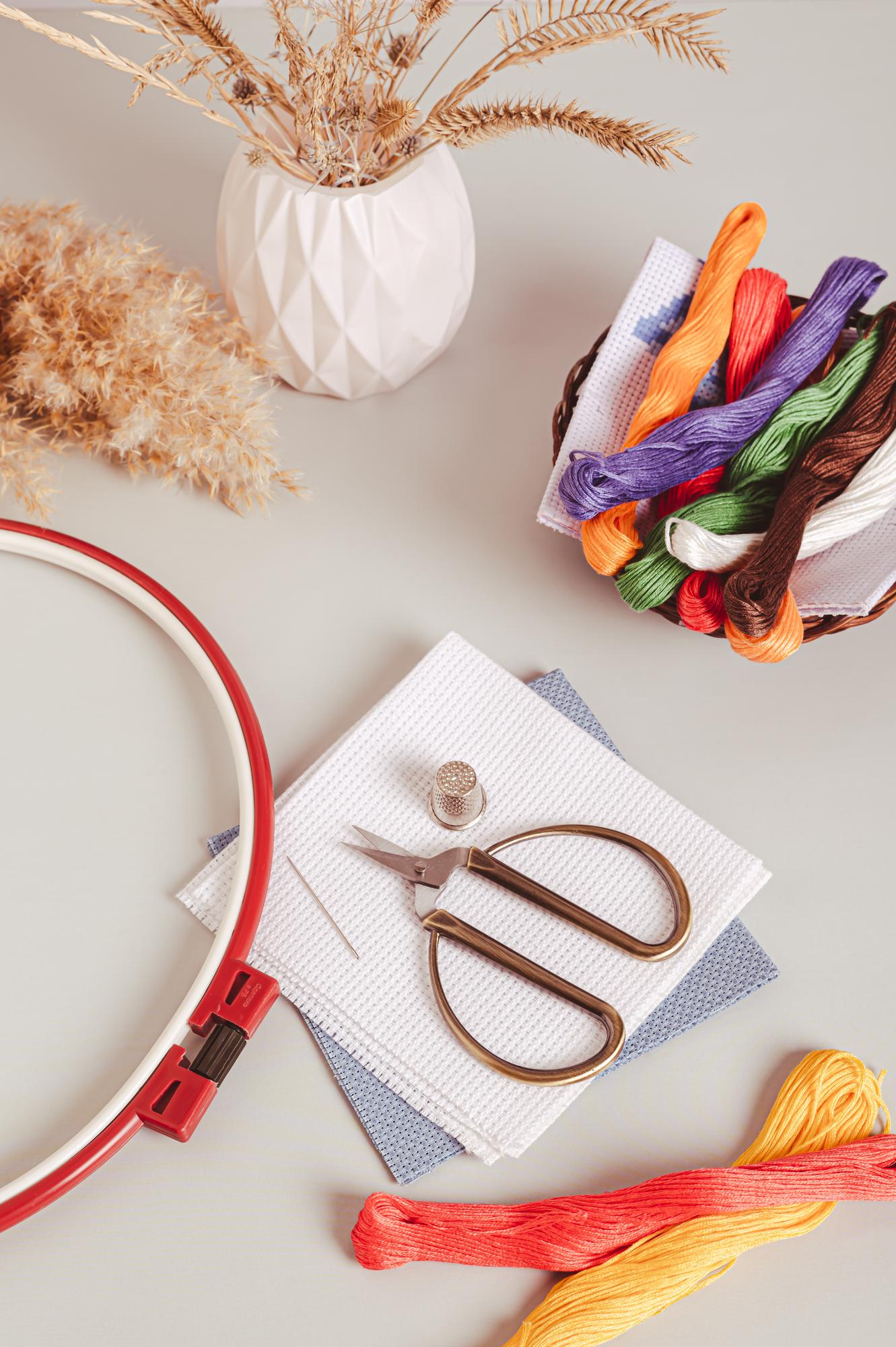 Laboratorio con attrezzi per il ricamo e fili colorati